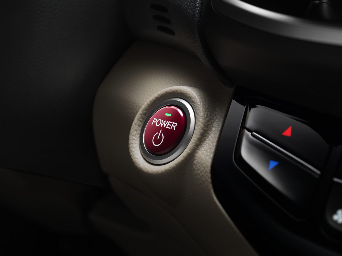 Close-up of a car's red engine start/stop button.