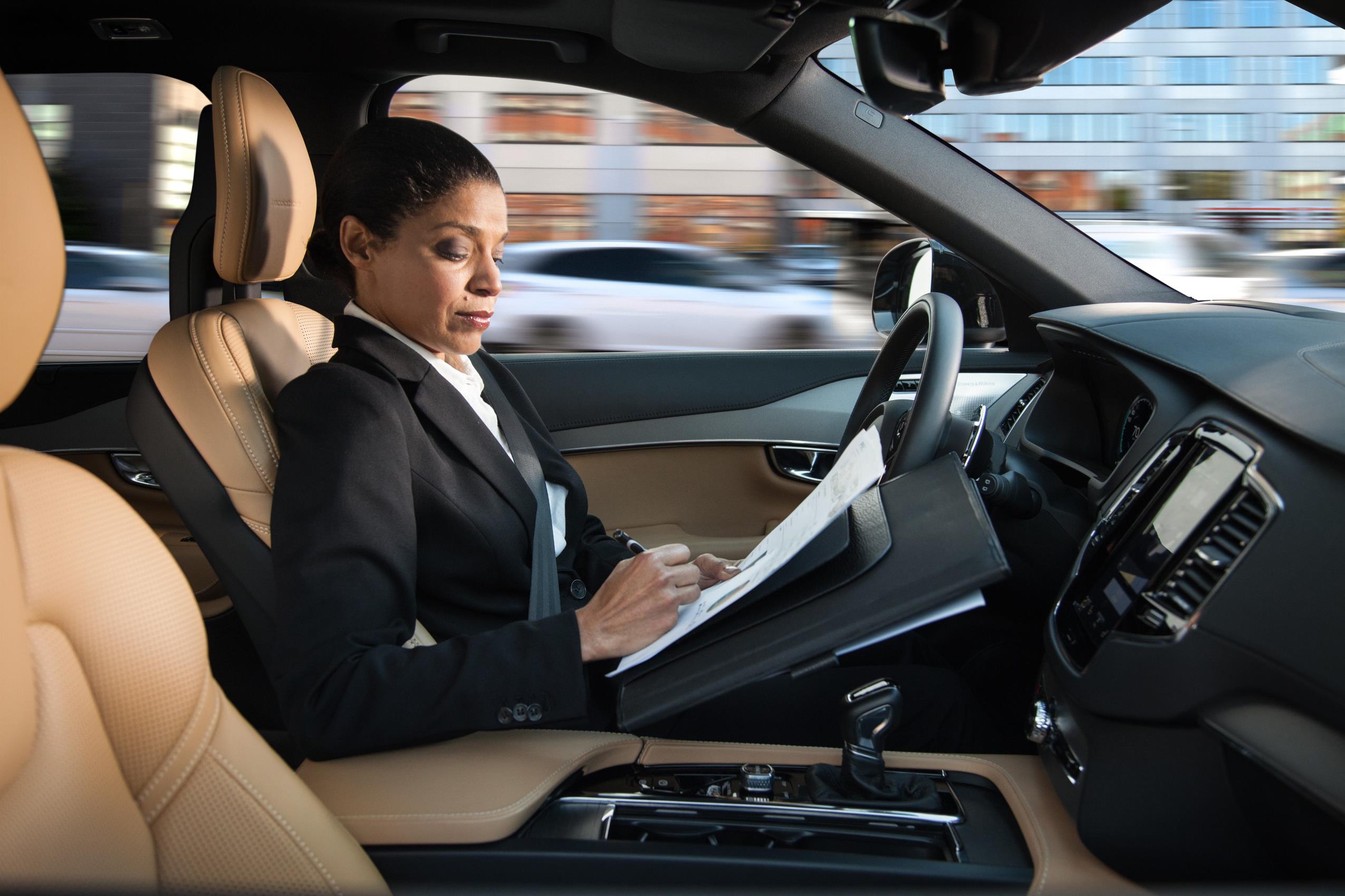 Professional woman reviewing documents inside a car.
