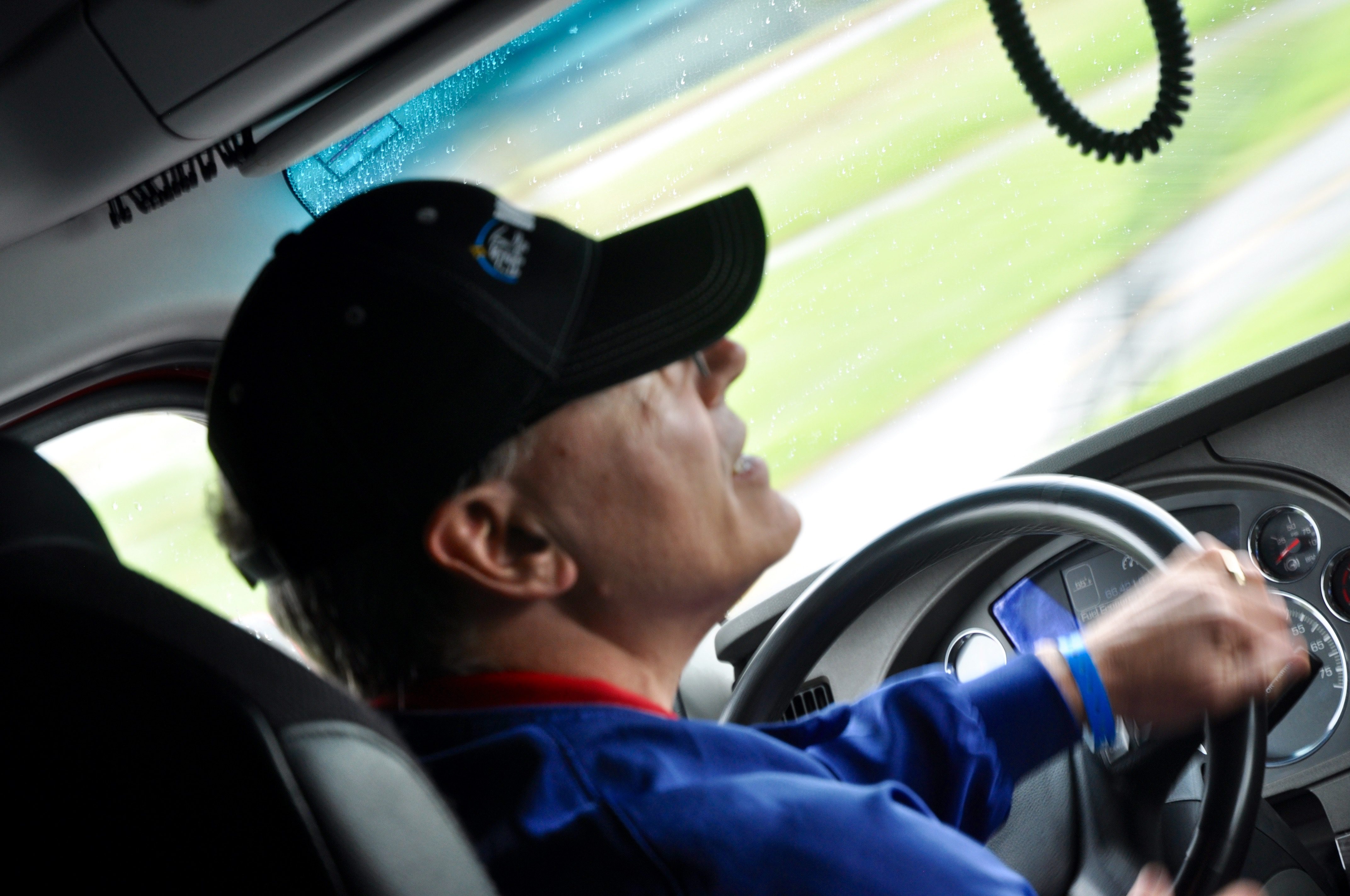 Man driving a car, focused on the road ahead.