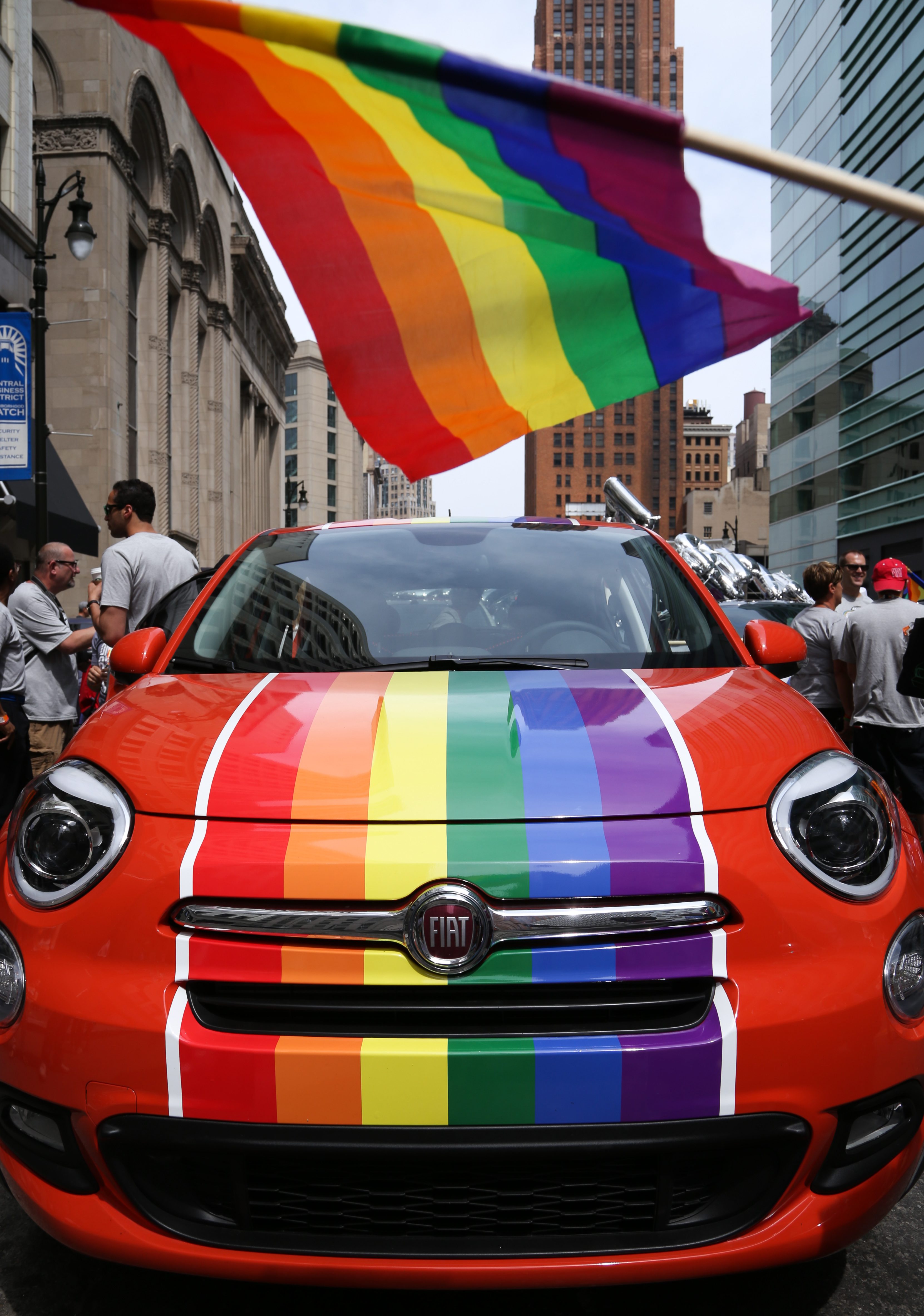 A car decorated with rainbow colors at a pride parade.