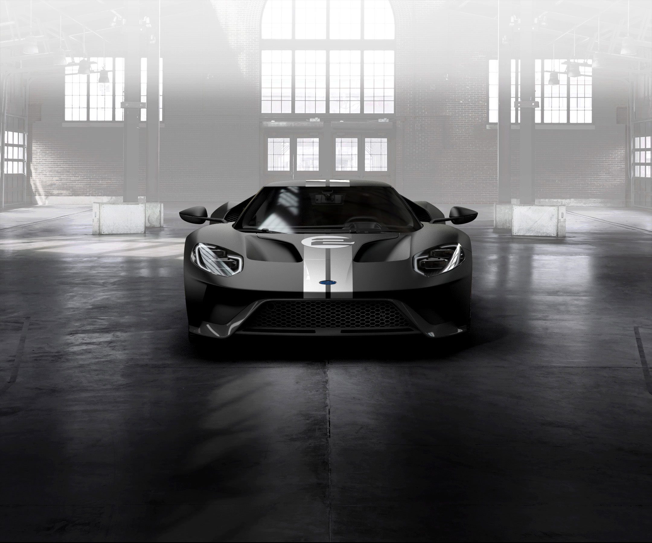 Sleek racing car parked inside a garage with dramatic lighting.
