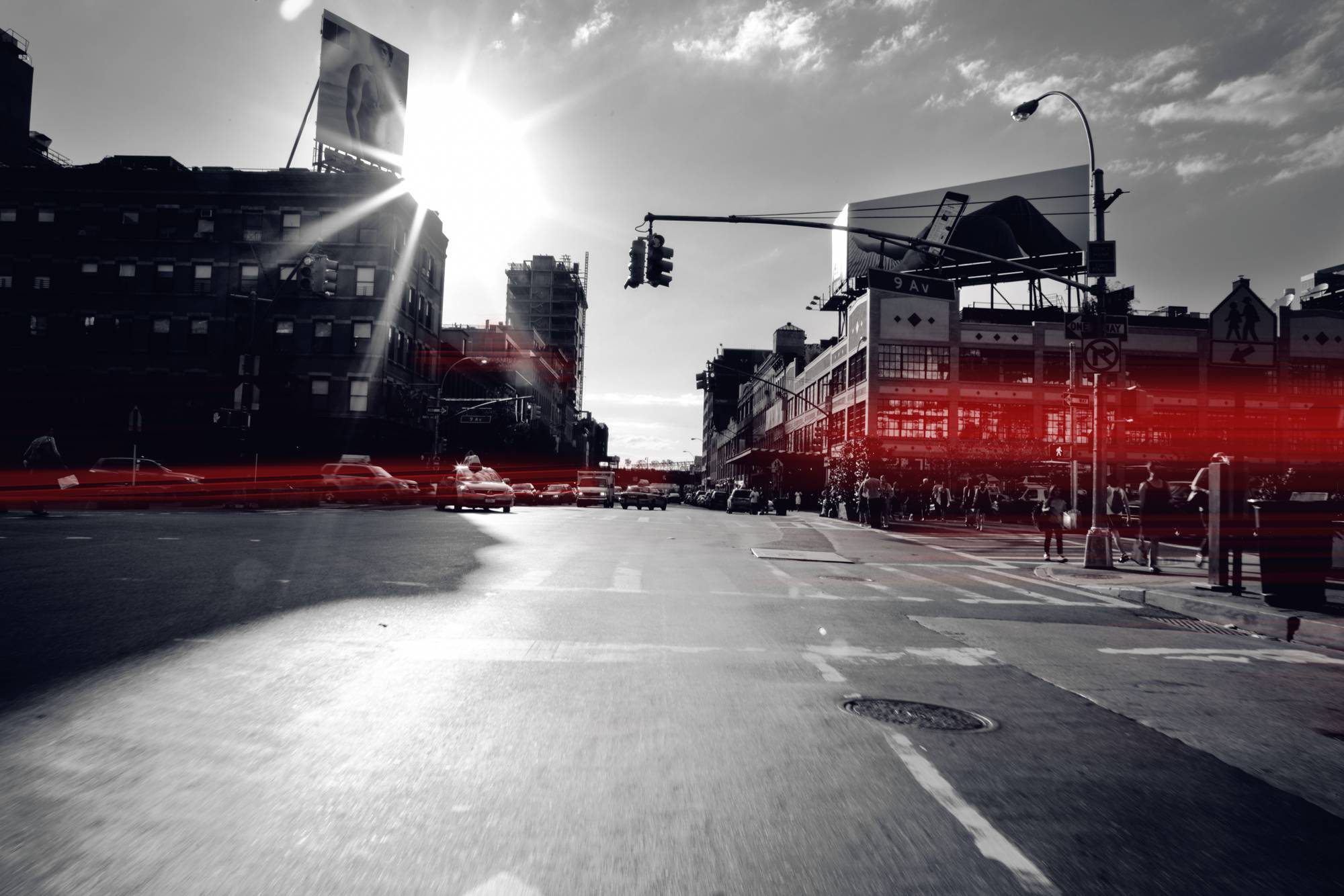Urban street with traffic lights and red-tinted reflections at sunset.