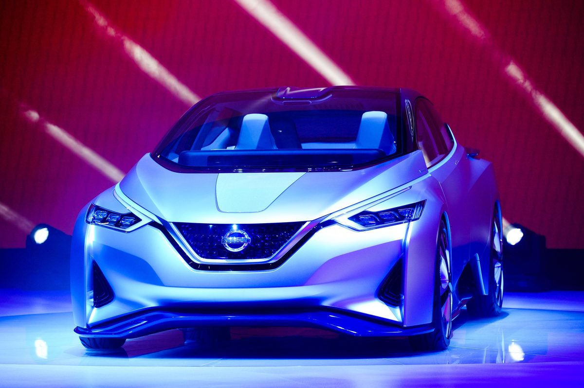 Futuristic silver Nissan concept car showcased under vibrant lighting.