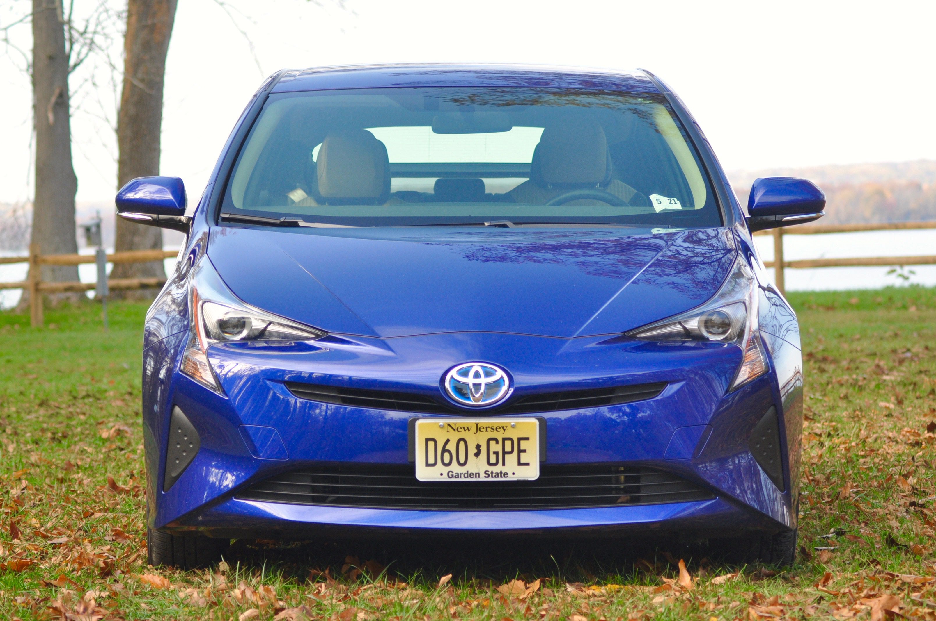 Blue Toyota Prius parked on grass with a New Jersey license plate.