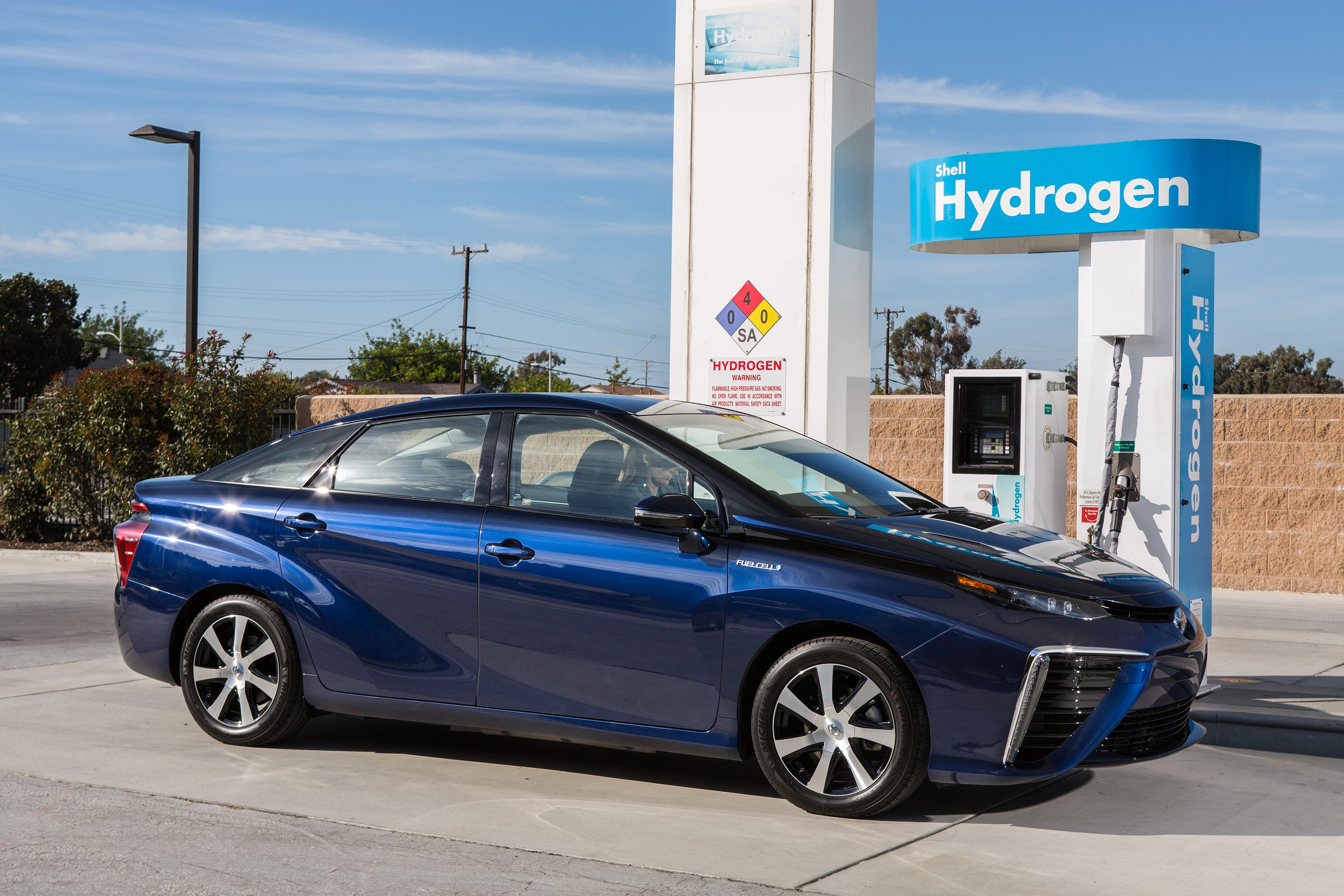 Blue hydrogen fuel cell car at a hydrogen refueling station.