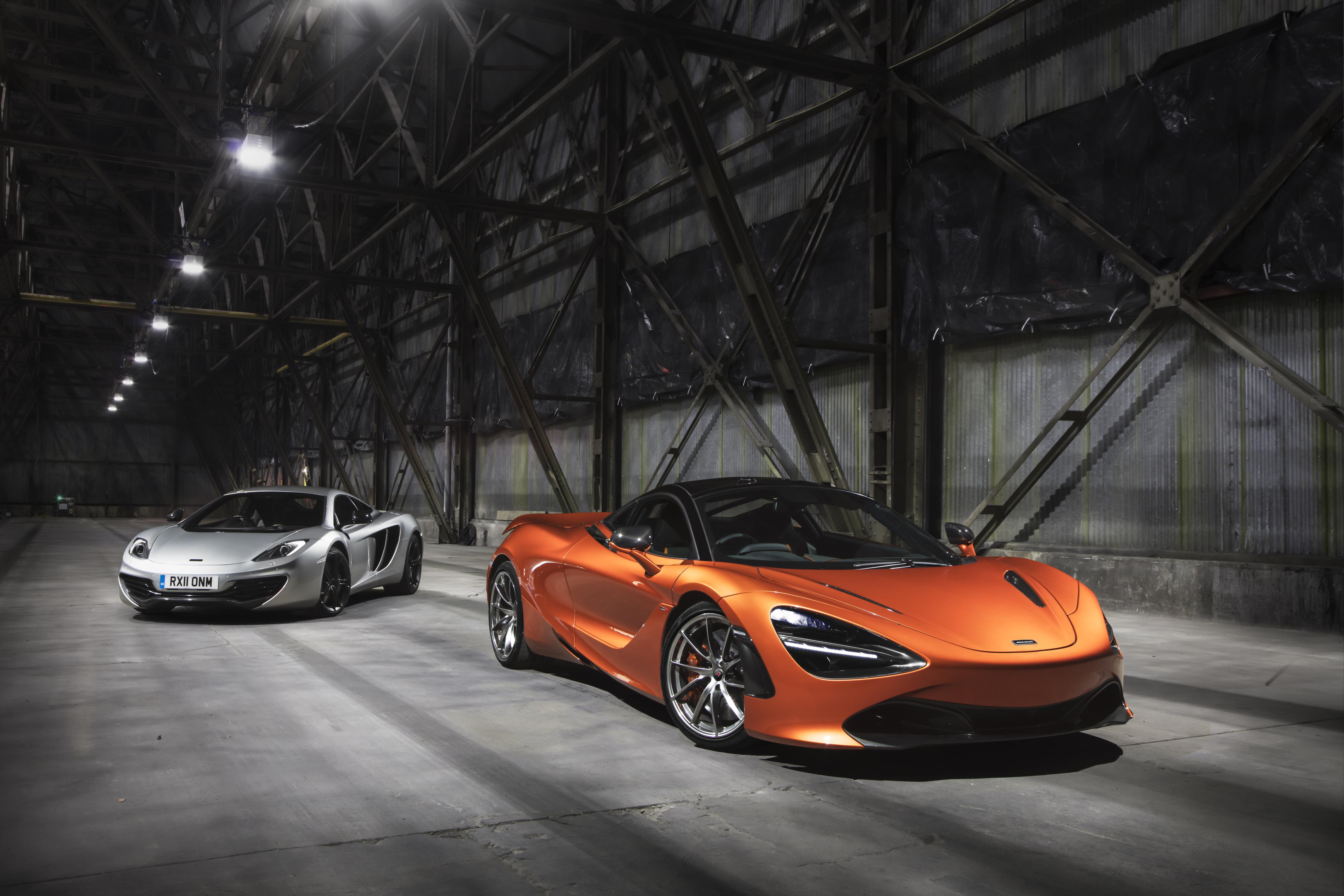 Two luxury sports cars parked inside a dimly lit industrial building.