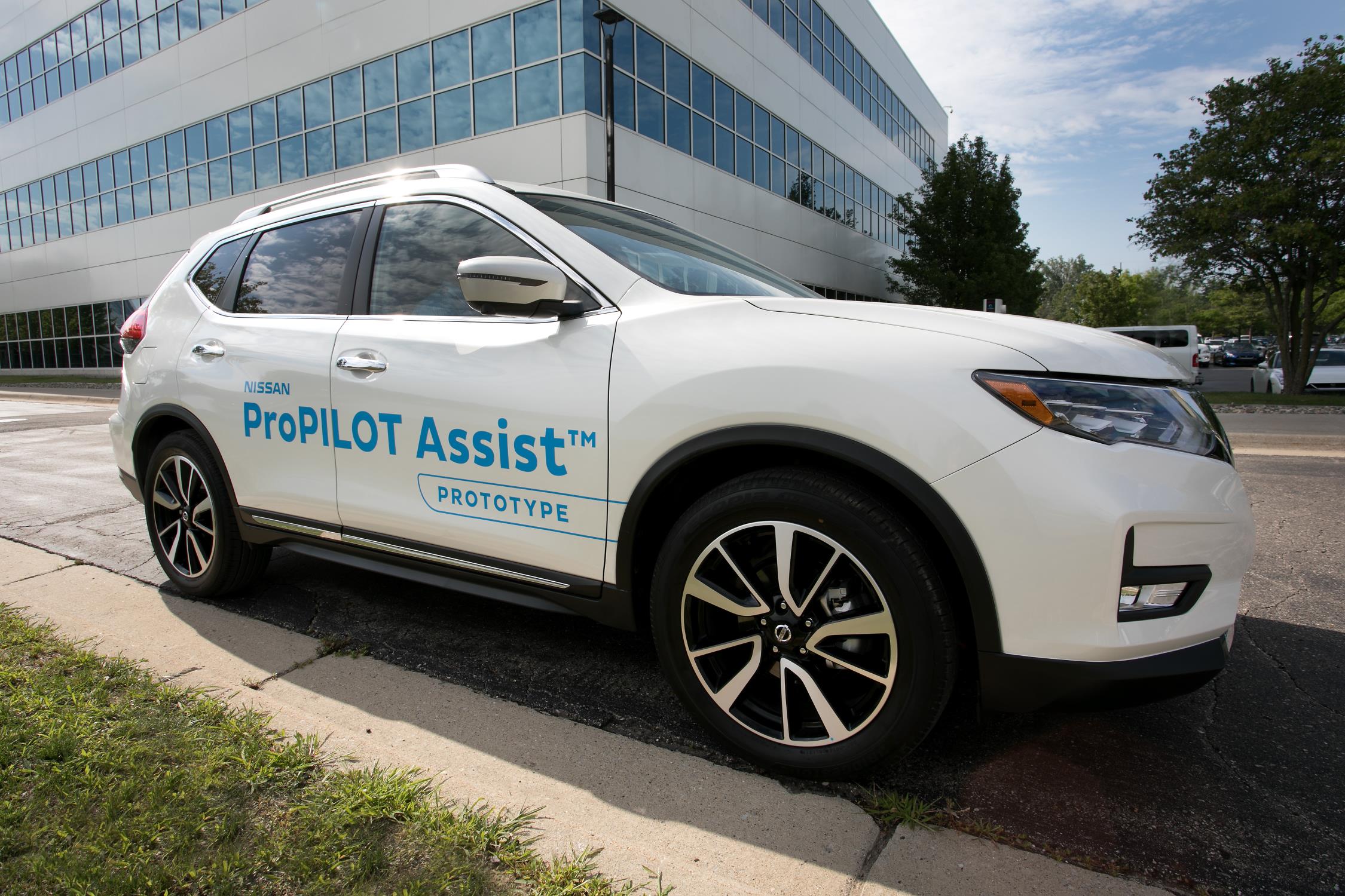 White SUV with ProPILOT Assist branding parked outside a modern building.