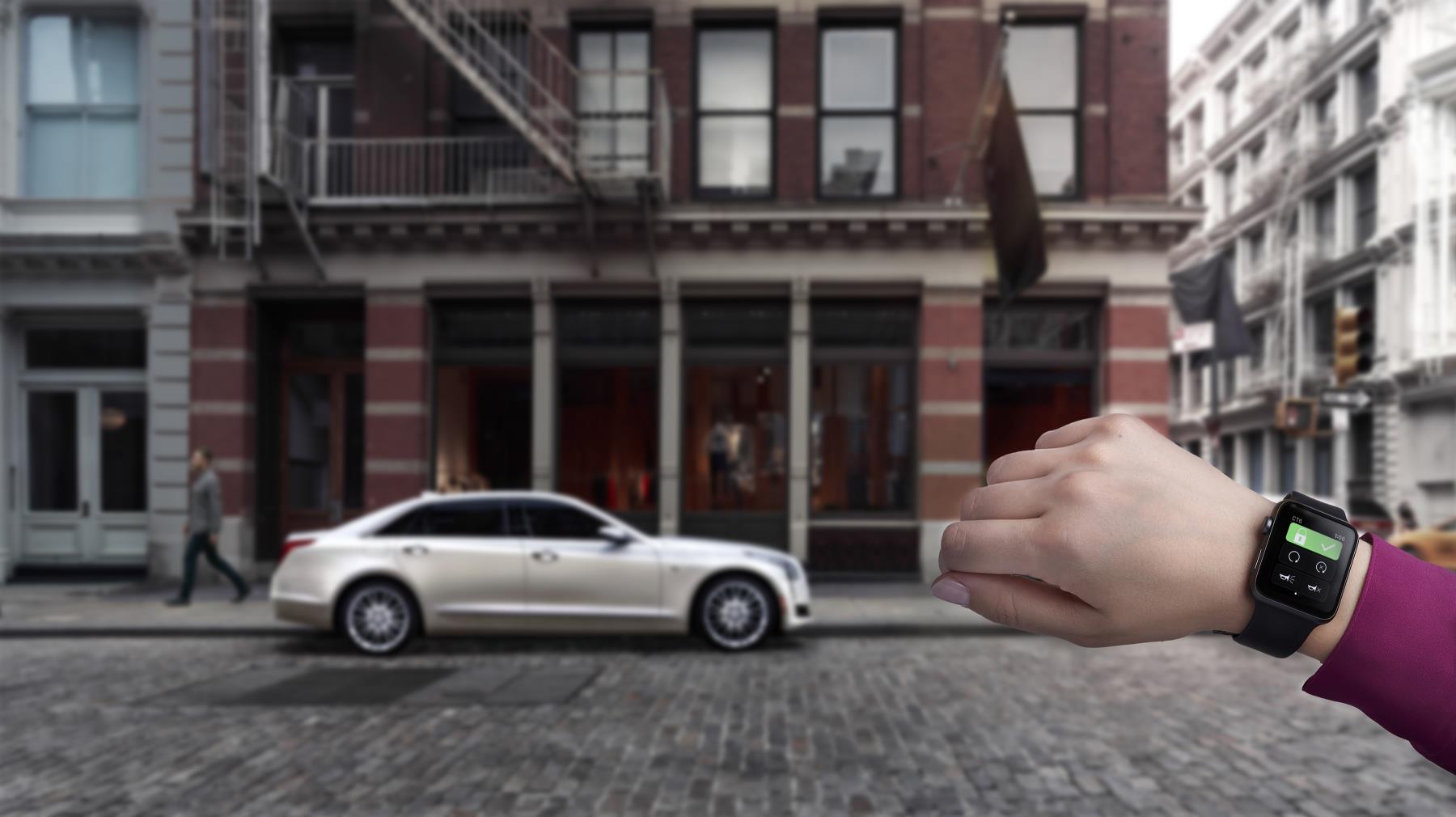 A hand appears to pinch a miniature white car on a city street.