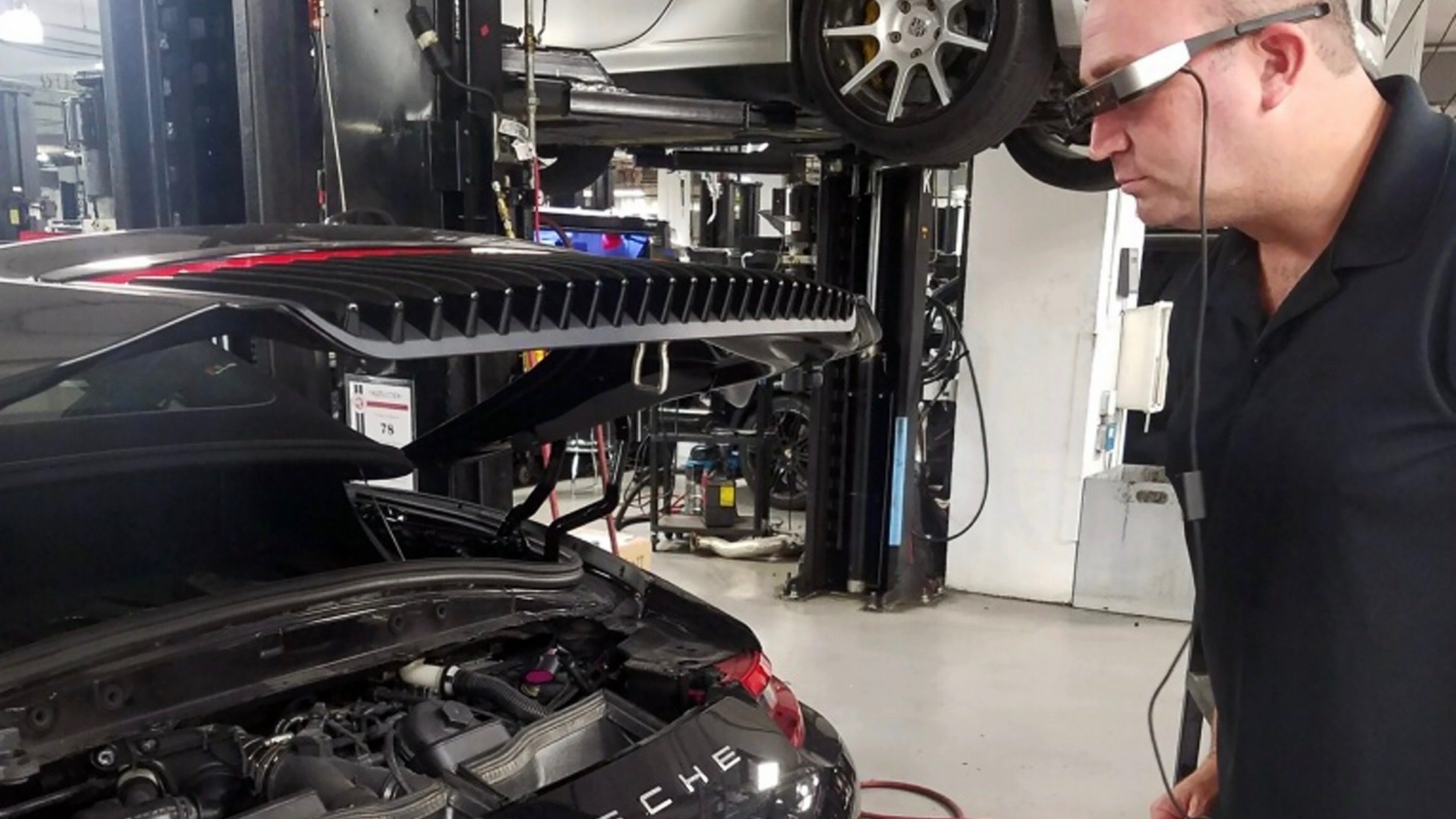 Car undergoing repair in a professional auto workshop.