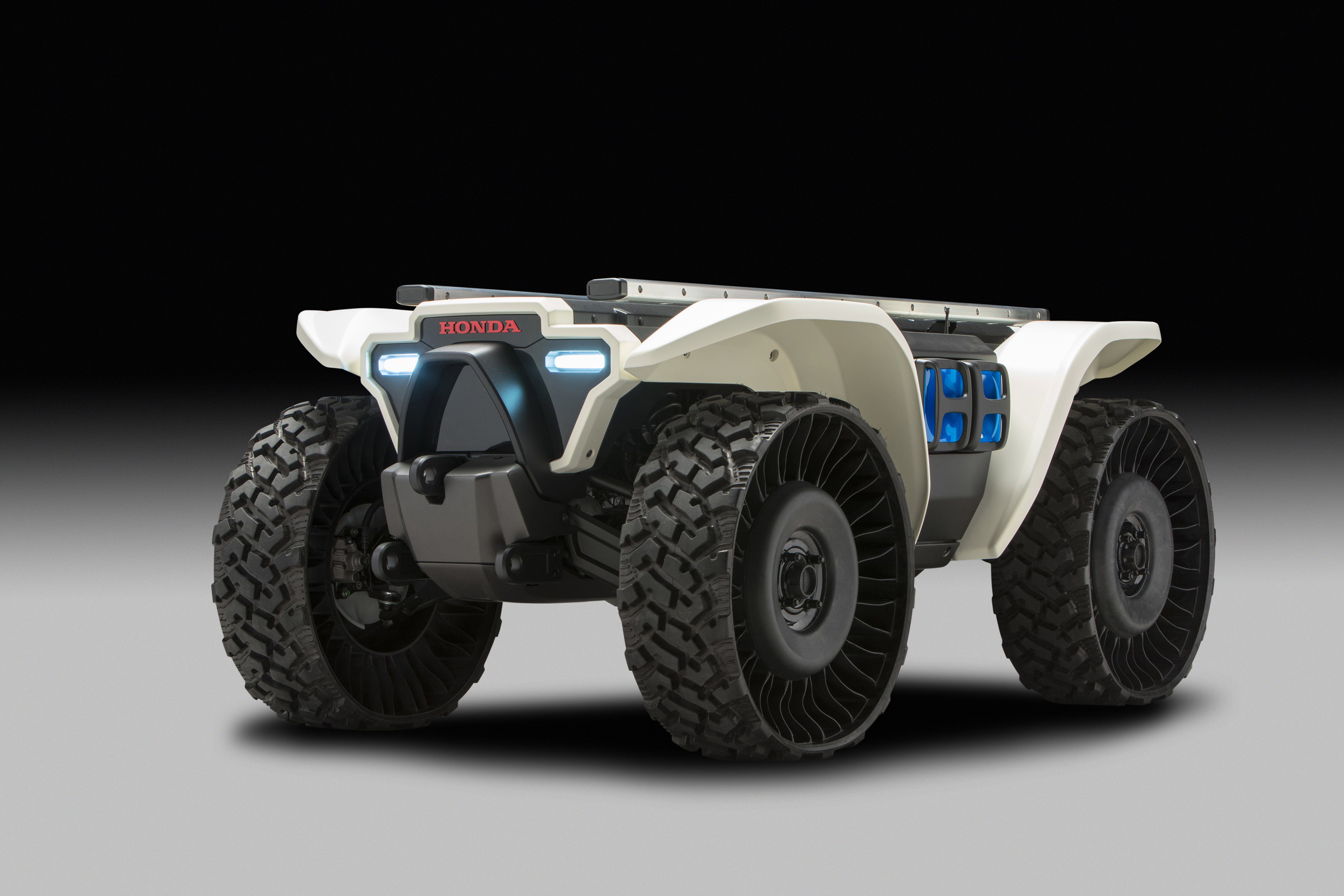 A rugged, futuristic off-road vehicle with large tires and a white body.