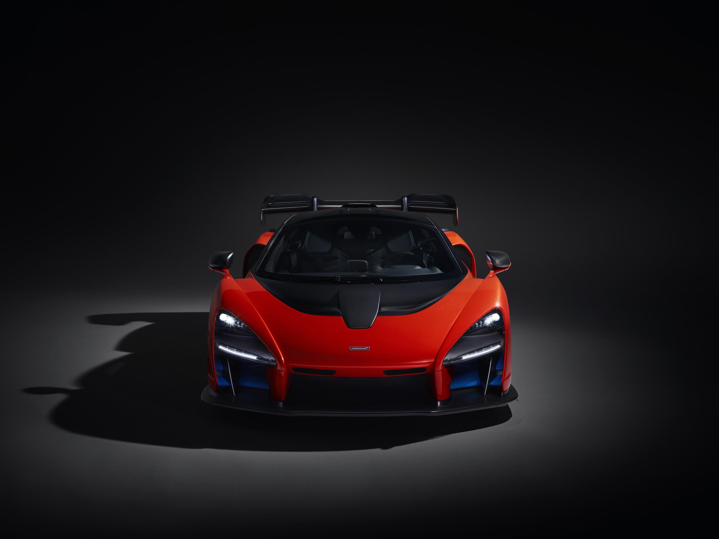 Front view of a sleek red sports car in dramatic lighting.