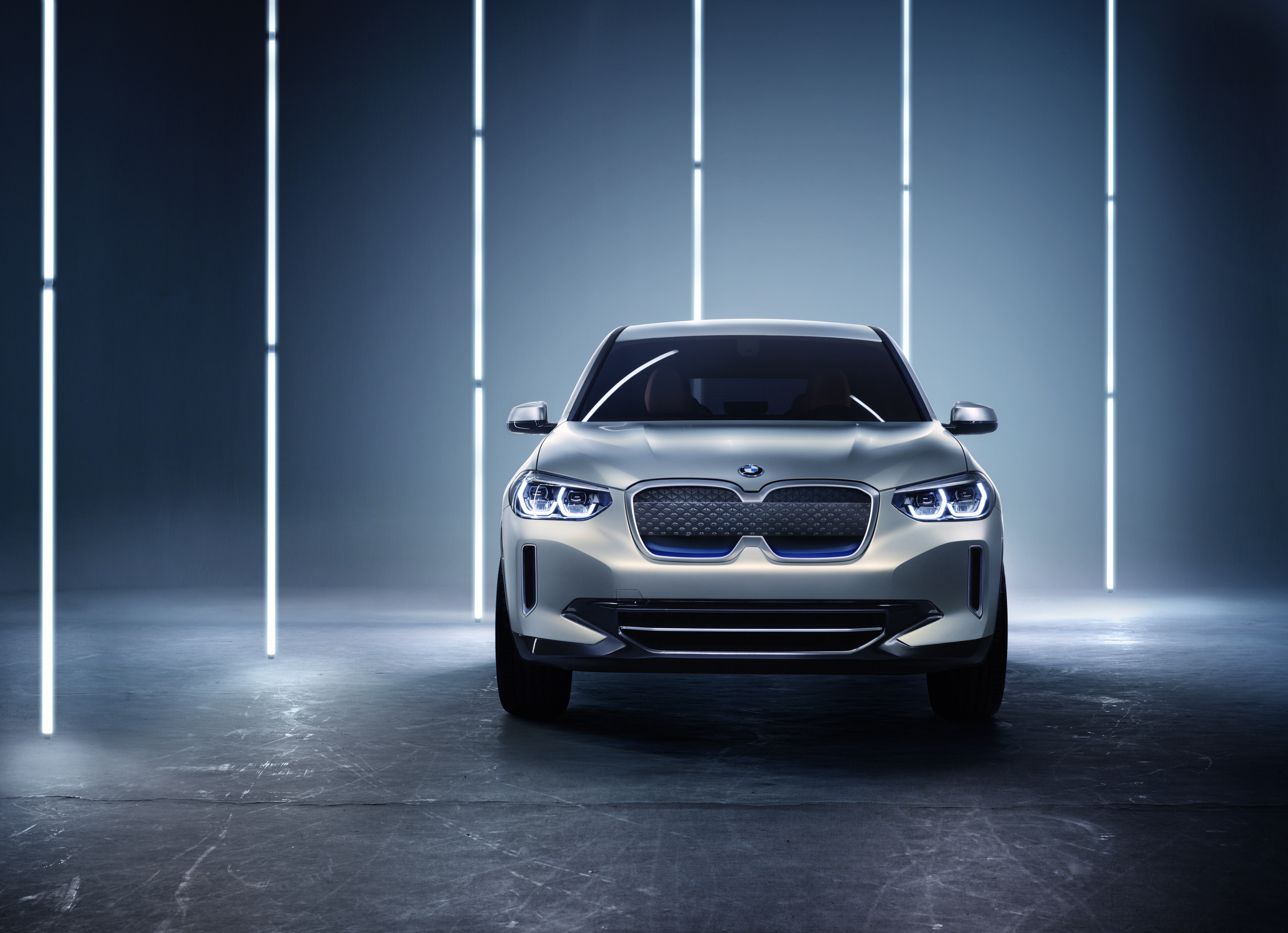 Front view of a sleek white luxury SUV under modern lighting.