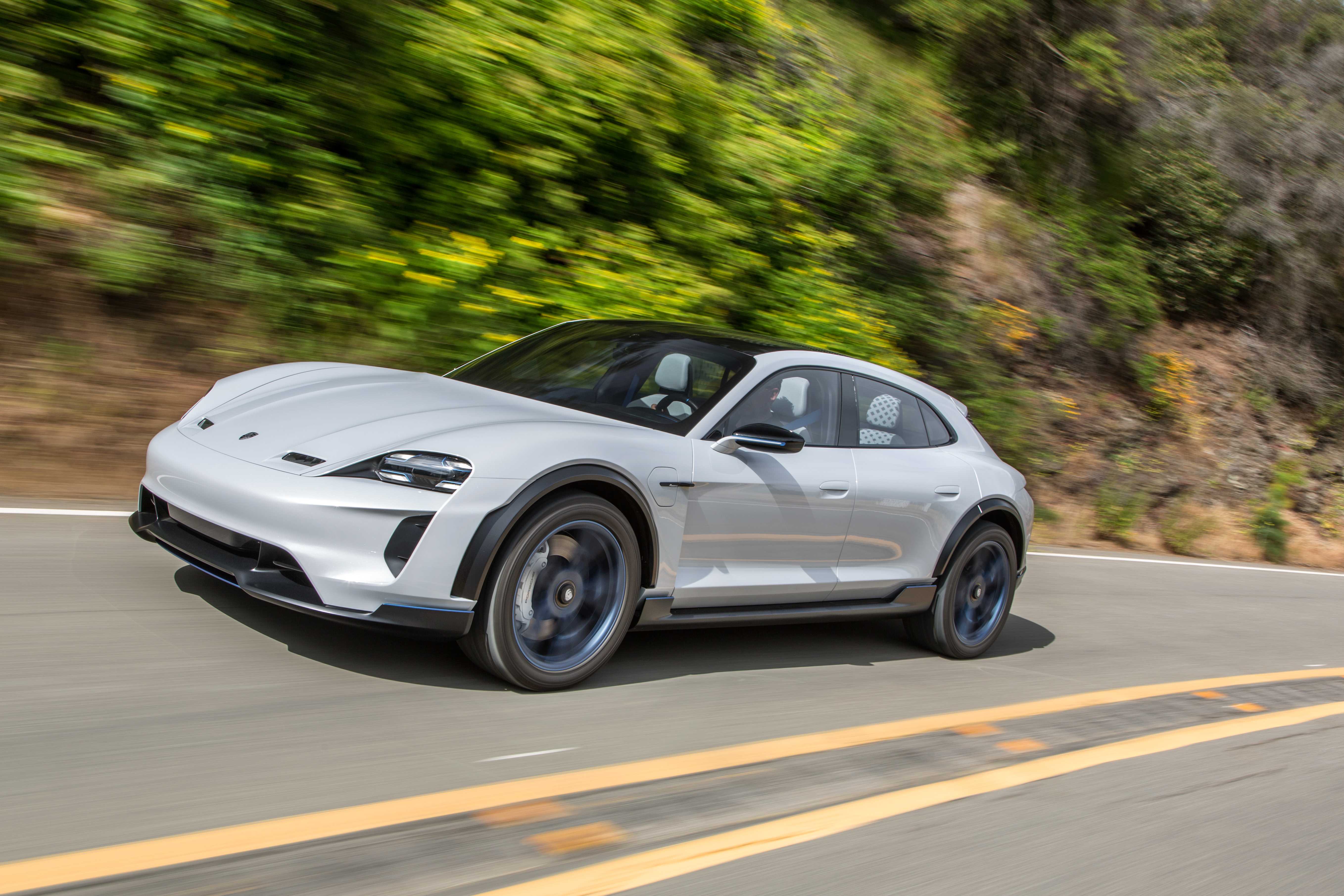 Silver electric SUV driving on a winding mountain road.