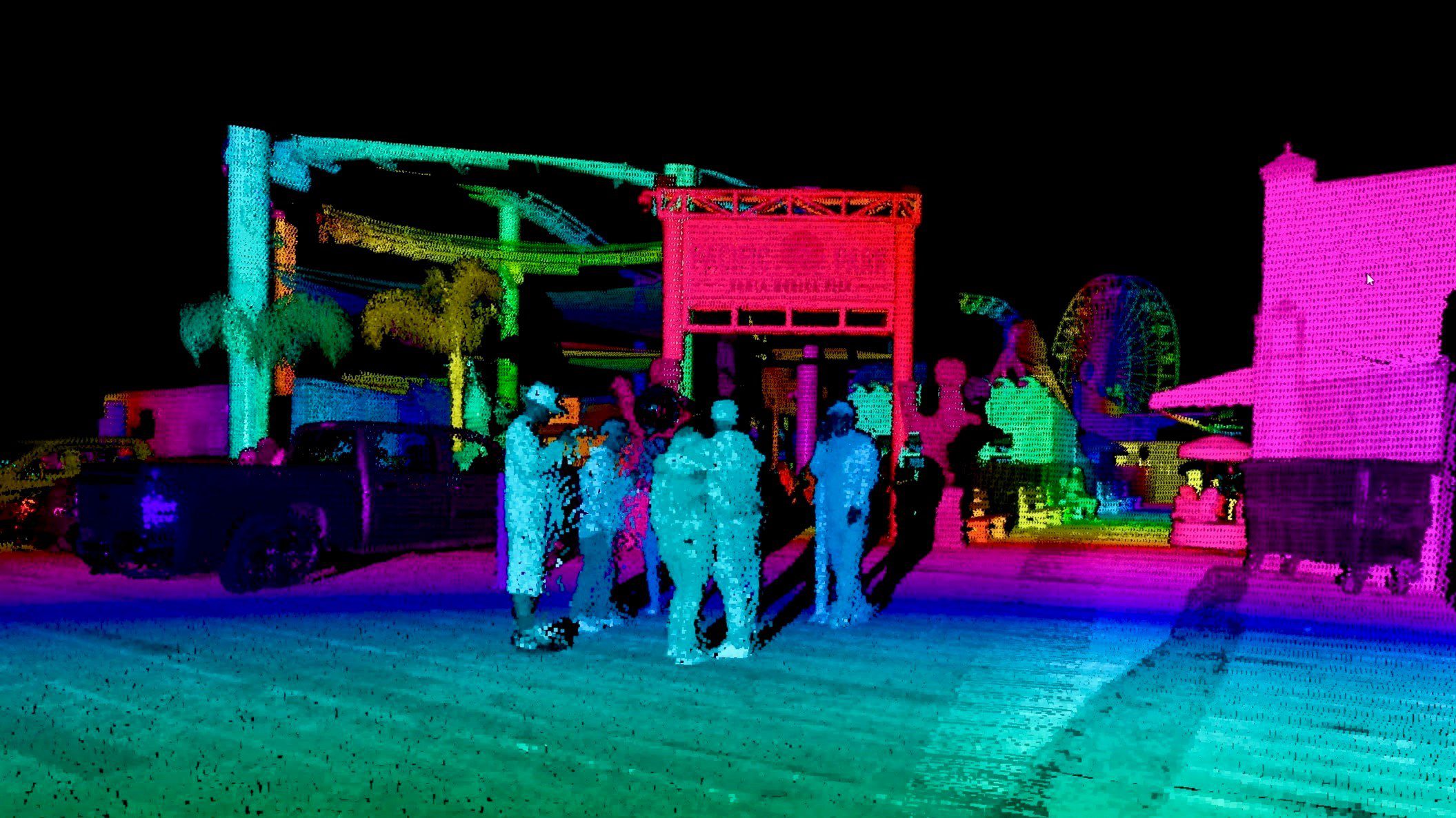 People enjoying a colorful illuminated water park at night.