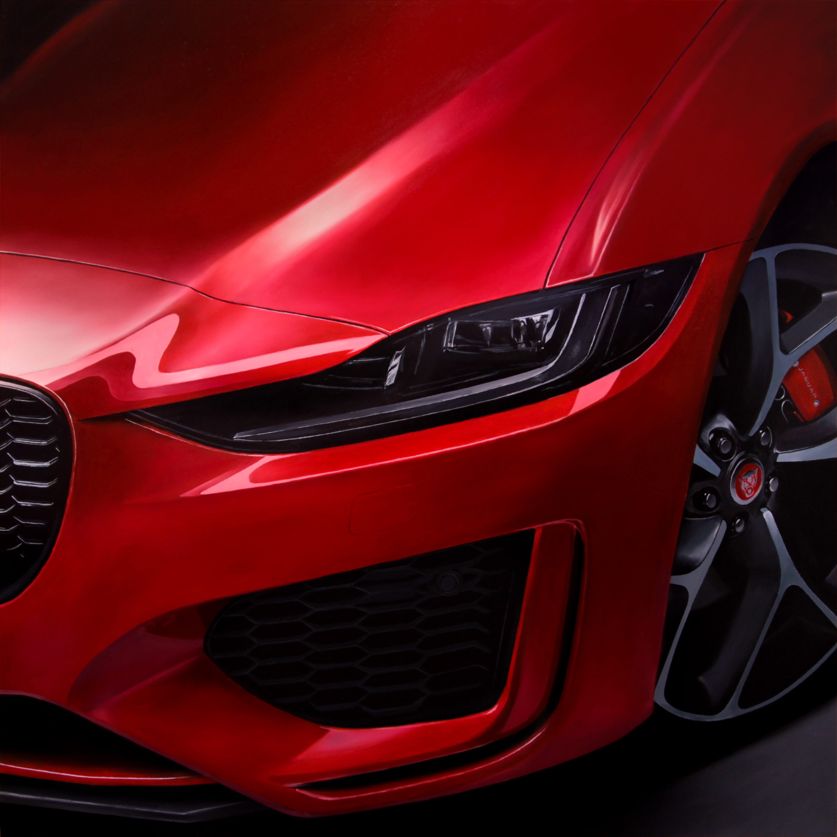 Close-up of a sleek red sports car headlight and front grille.