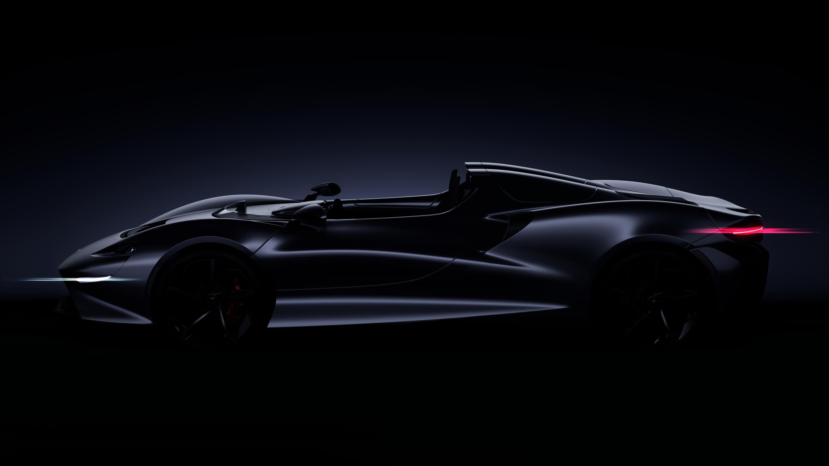 Sleek black convertible sports car in low light.