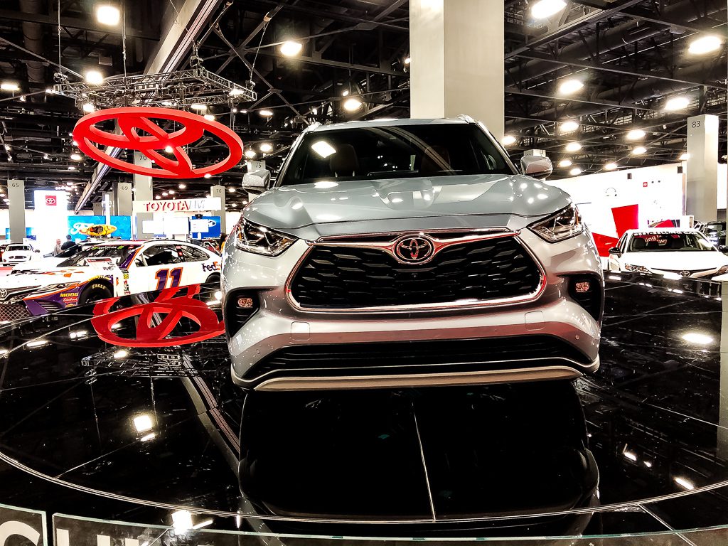 Front view of a silver Toyota SUV displayed indoors with bright lights.