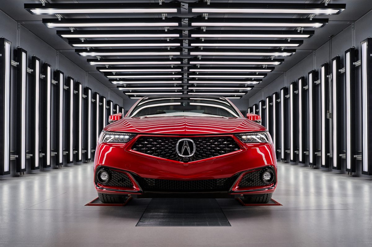 Red Acura sedan displayed in a futuristic tunnel with LED lighting.