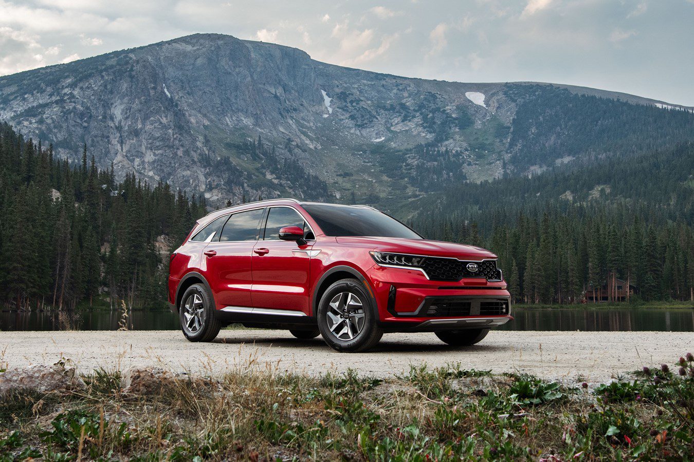 Red SUV parked outdoors with mountains in the background.