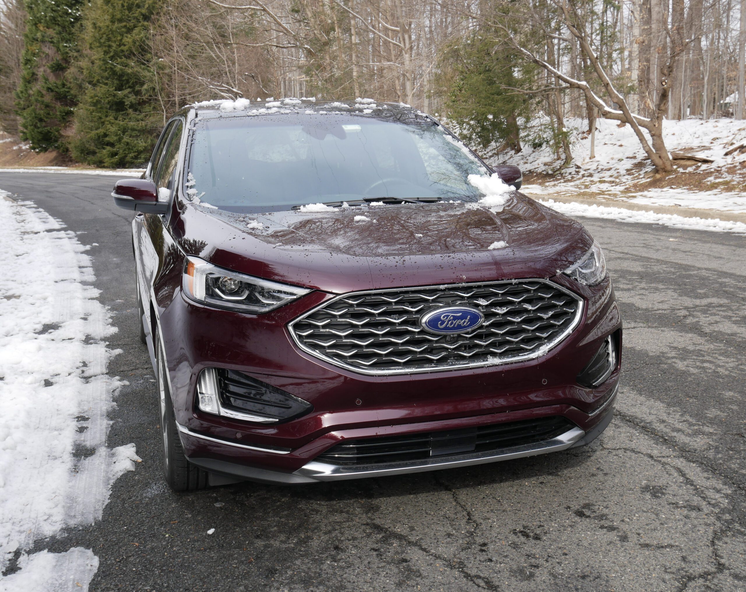 A maroon Ford SUV parked on a snowy driveway.