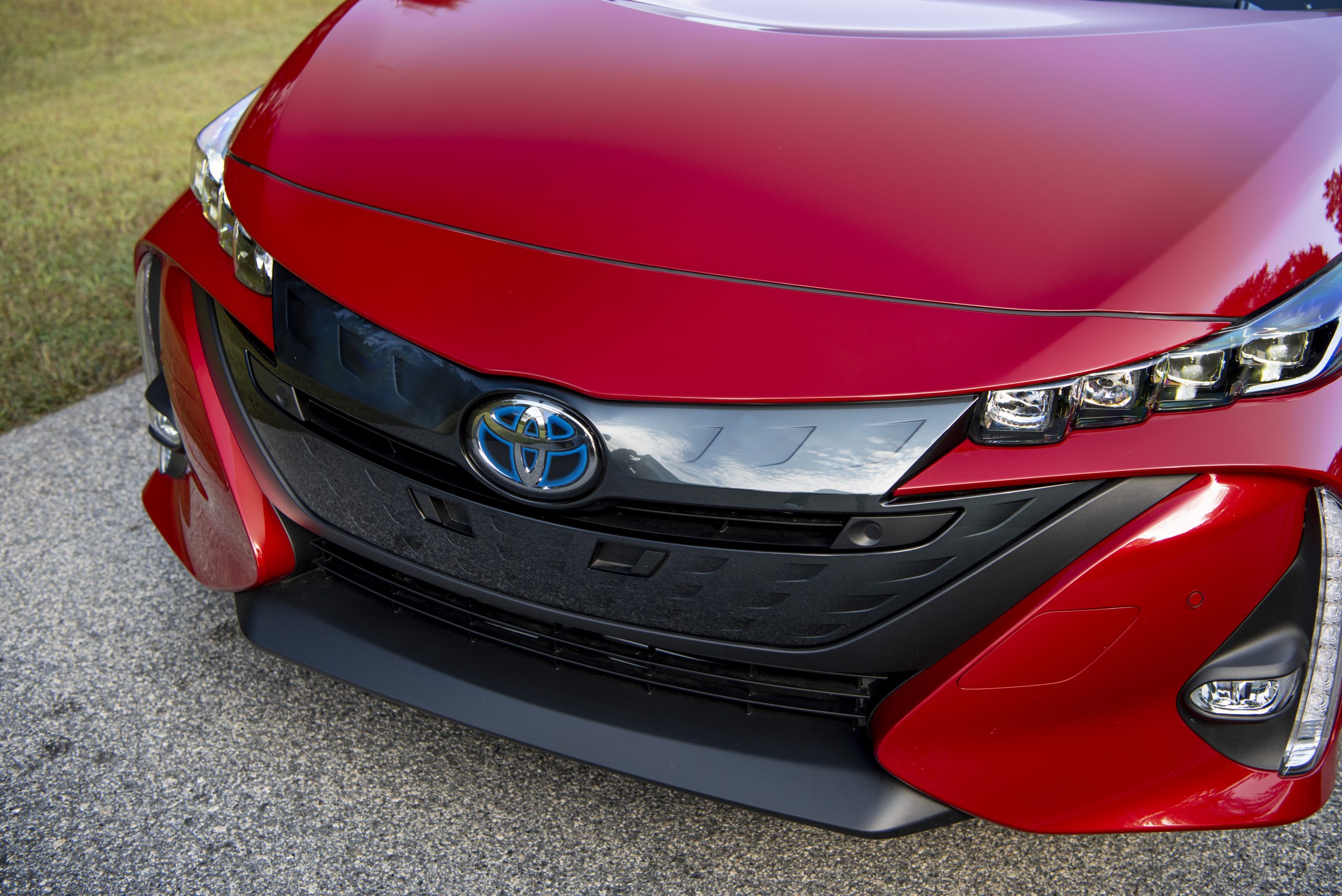 Close-up of a red Toyota car front with logo and grille.