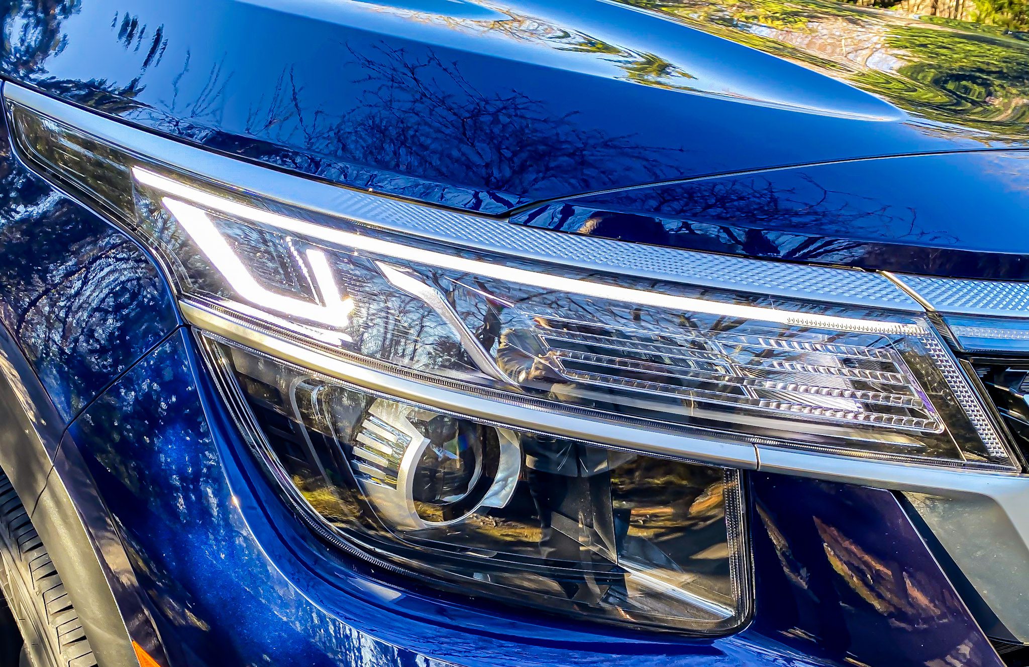 Close-up of a blue car's modern headlight design.