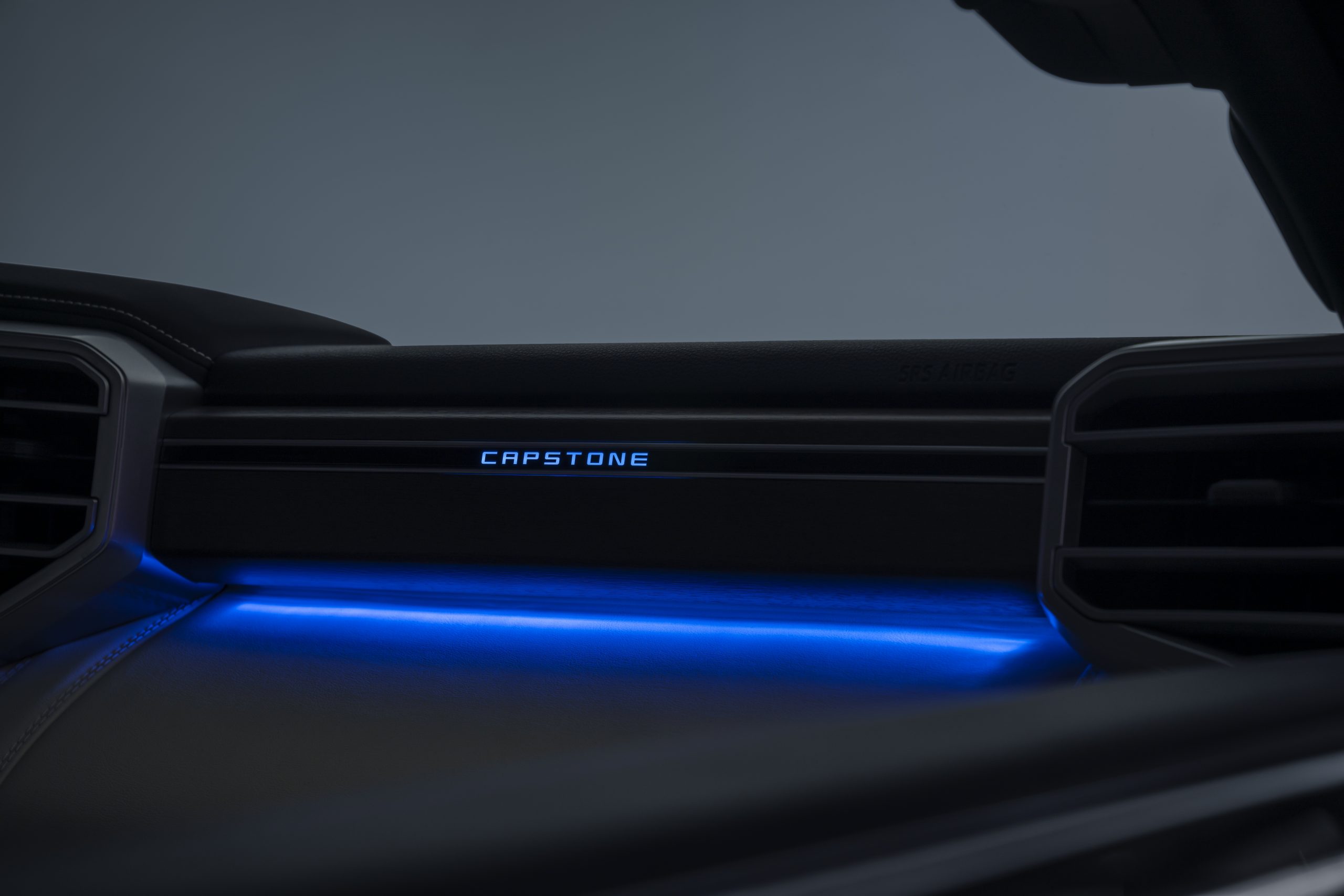 Car dashboard with illuminated blue ambient lighting and CAPTURING text.