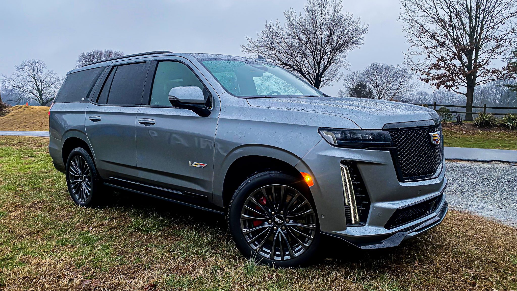 Sleek gray SUV parked on grass with modern design and stylish wheels.