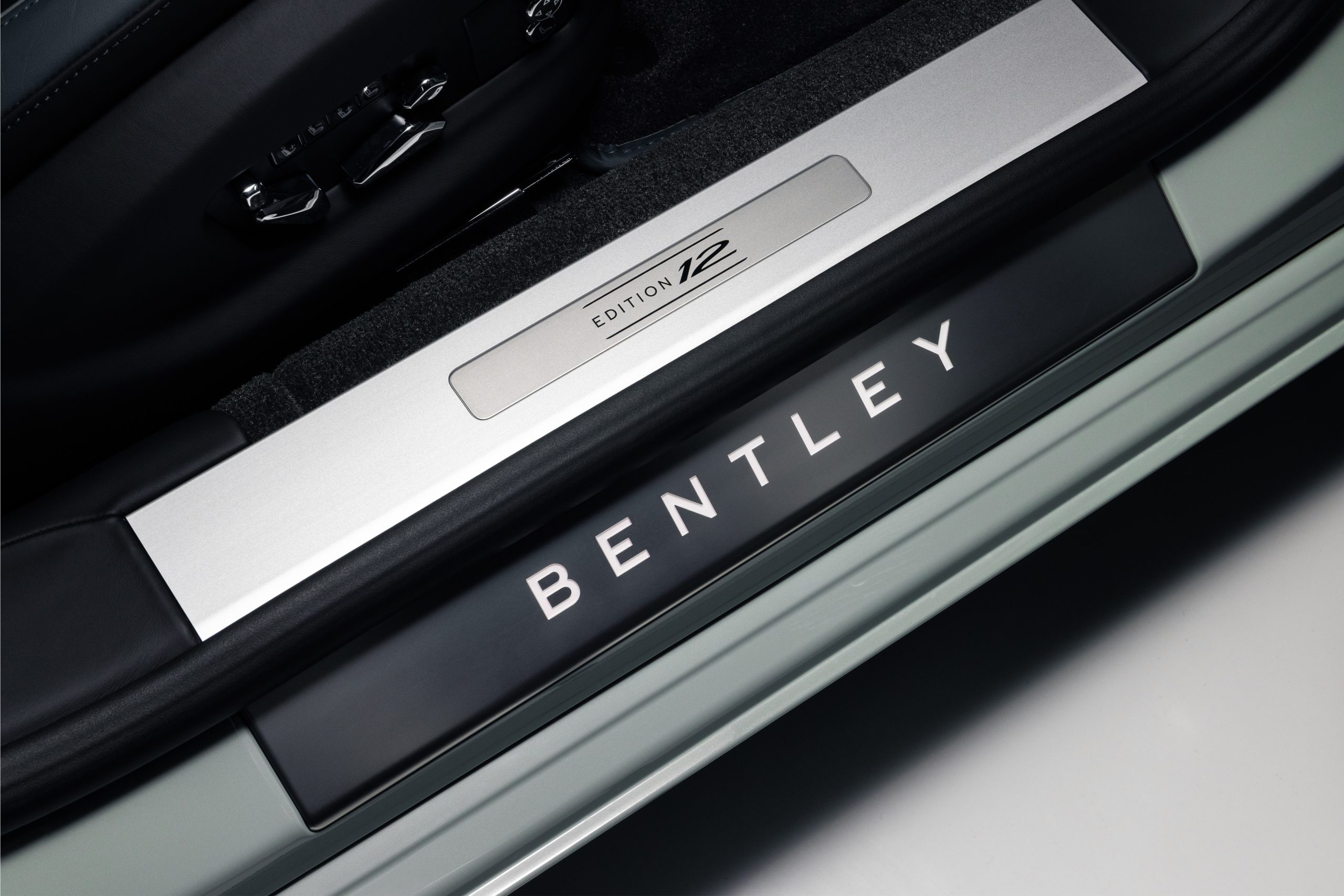 Close-up of Bentley car door sill with illuminated logo.