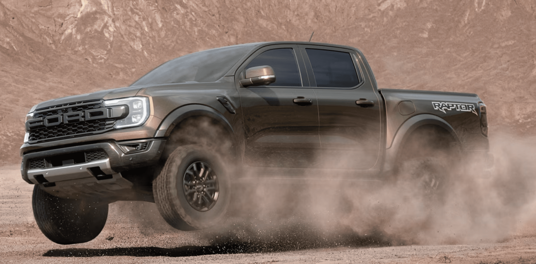 A rugged black pickup truck kicking up dust on a dirt road.