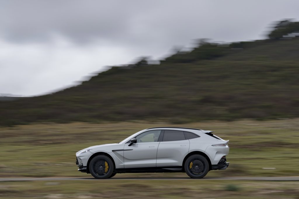 Aston Martin DBX707 navigating a winding mountain road: "DBX707 effortlessly conquering a scenic mountain road, embodying its high-performance capabilities."
