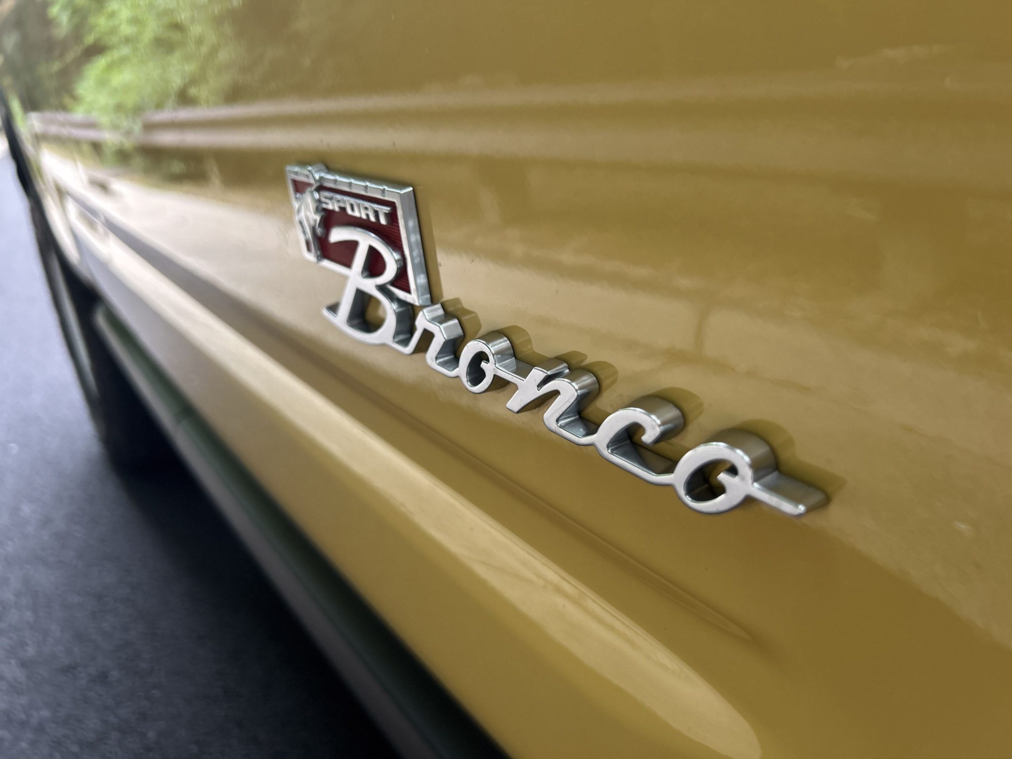 Close-up of a yellow Ford Bronco emblem on a vehicle.