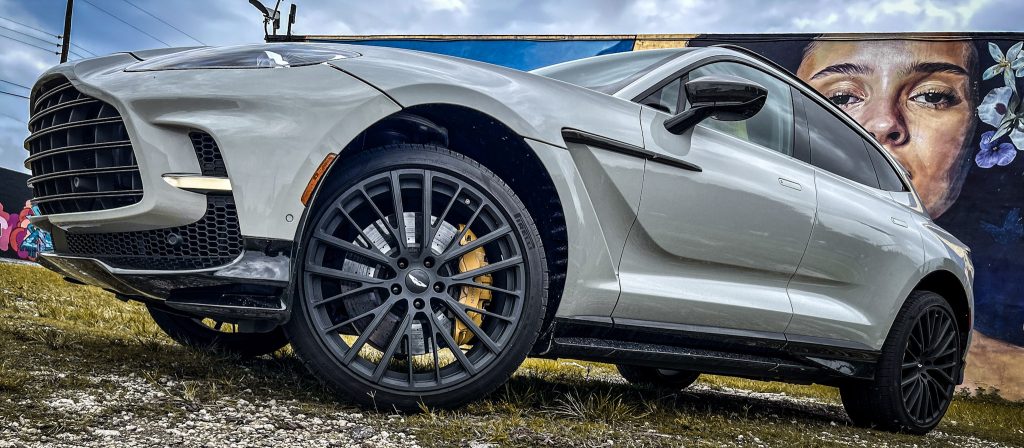 Image of Aston Martin DBX707 in front of a luxury mansion: "Aston Martin DBX707 parked in front of an elegant mansion, showcasing its powerful and luxurious appeal."