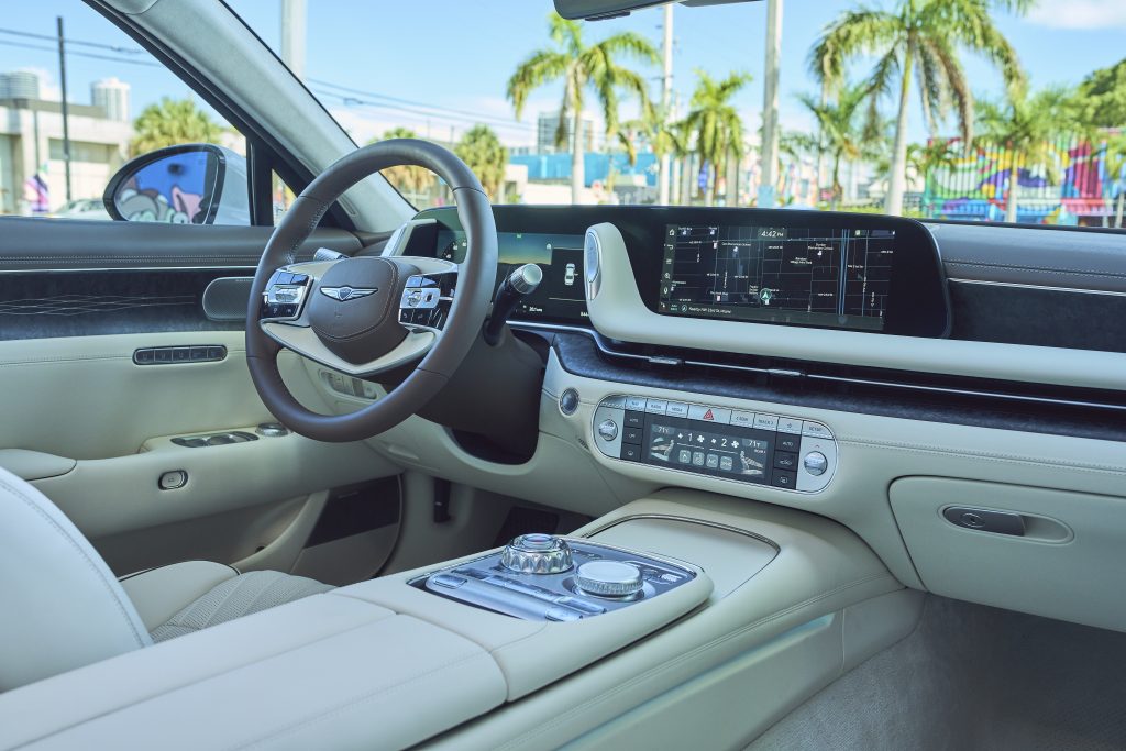 Luxurious interior of the 2023 Genesis G90, featuring leather upholstery, wood accents, and a high-tech infotainment display, creating a refined ambiance.