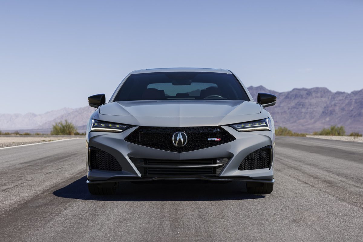 Front view of a sleek silver Acura sedan on a desert road.