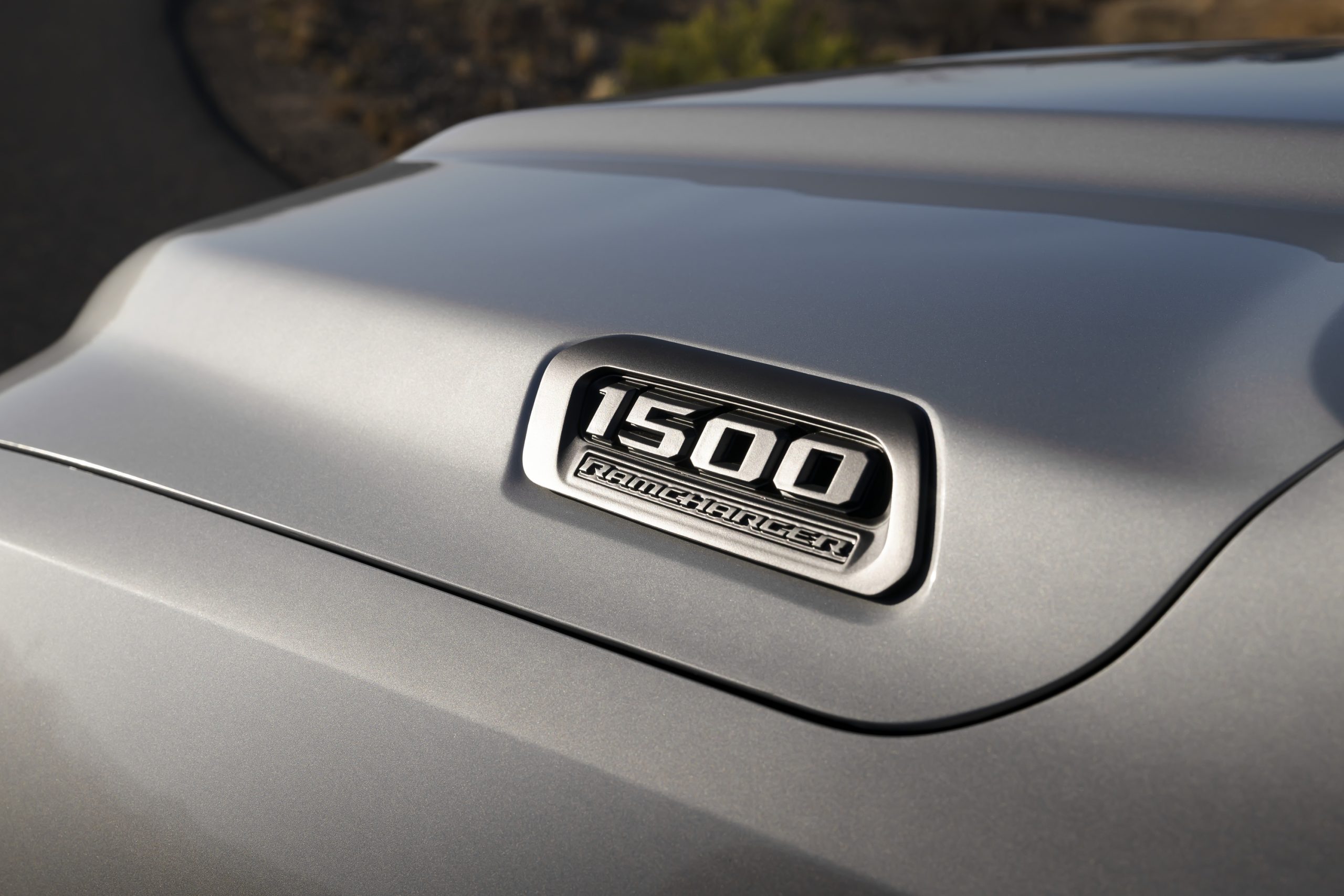 Close-up of a 1500 model badge on a silver vehicle.