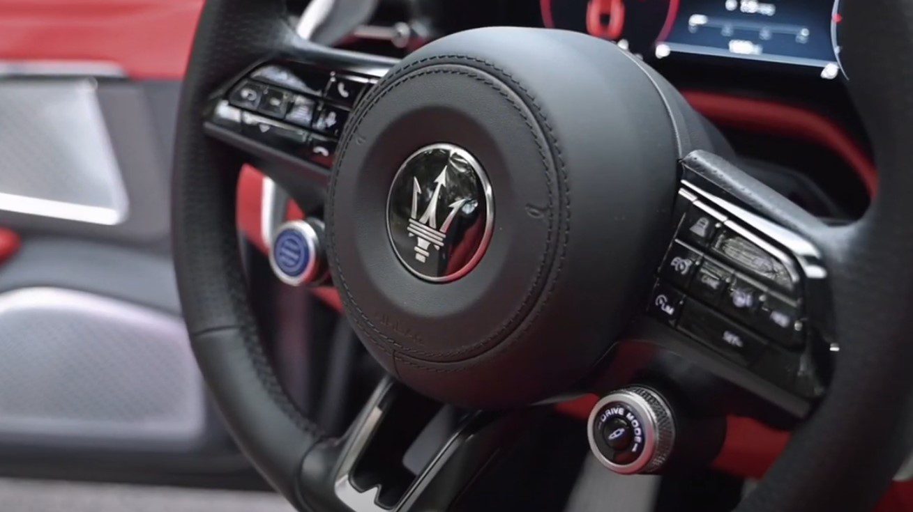 Close-up of a Maserati steering wheel with luxury interior details.