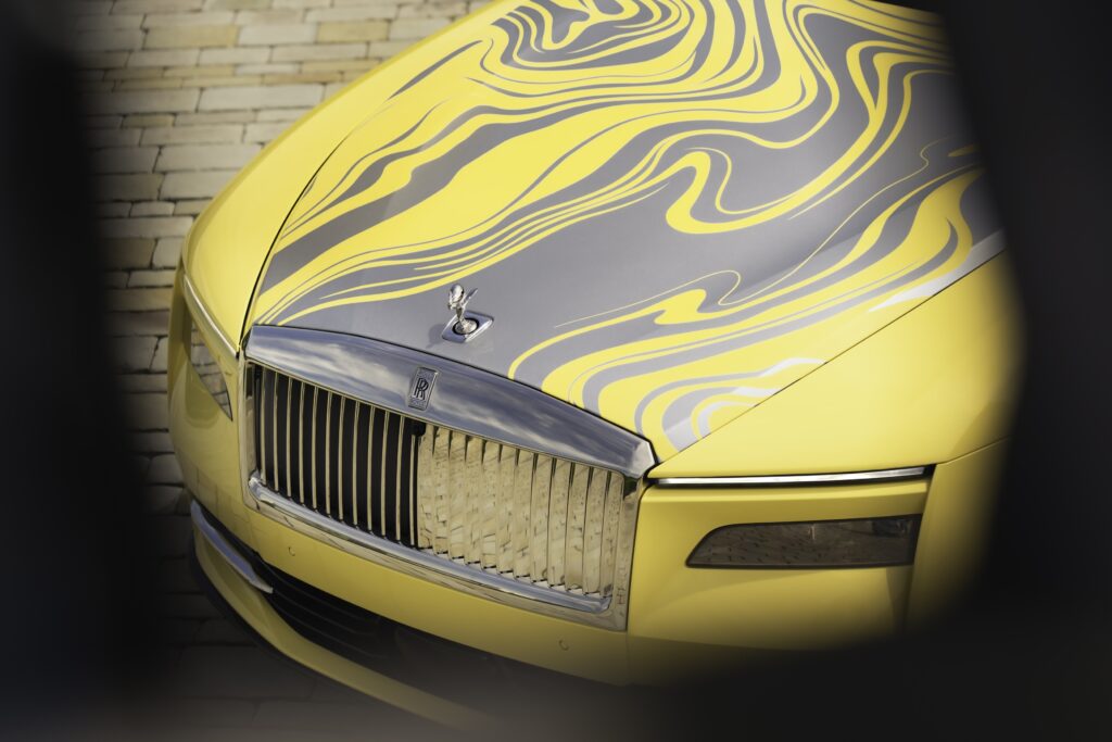 Rolls-Royce Spectre Semaphore in vibrant Semaphore Yellow with unique Marbled Paint Spill artwork on the bonnet, showcasing luxury craftsmanship at Monterey Car Week 2024