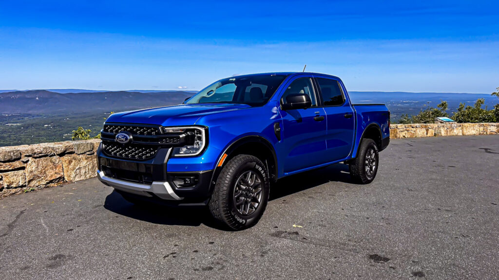 A dynamic image showcasing the **2024 Ford Ranger XLT SuperCrew 4x4** in **Velocity Blue Metallic**, featuring its rugged design, **off-road capability**, and **EcoBoost engine**. The truck is equipped with the **FX4 package**, offering **superior performance** on various terrains. Highlighted elements include **SYNC4 technology**, **towing capacity**, and the vehicle's **mid-size truck versatility**. Perfect for those seeking adventure, durability, and advanced **tech features** in a pickup.