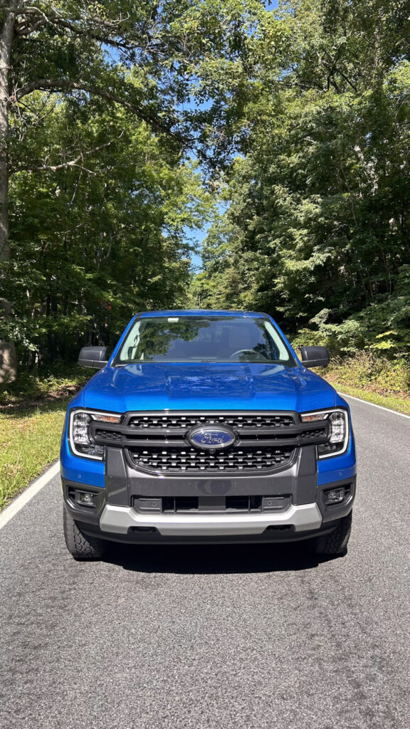 A dynamic image showcasing the **2024 Ford Ranger XLT SuperCrew 4x4** in **Velocity Blue Metallic**, featuring its rugged design, **off-road capability**, and **EcoBoost engine**. The truck is equipped with the **FX4 package**, offering **superior performance** on various terrains. Highlighted elements include **SYNC4 technology**, **towing capacity**, and the vehicle's **mid-size truck versatility**. Perfect for those seeking adventure, durability, and advanced **tech features** in a pickup.