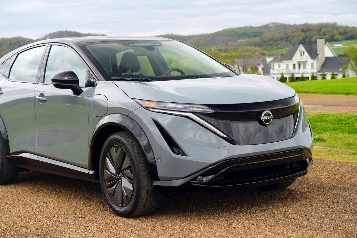 A sleek silver Nissan Ariya electric SUV parked outdoors.