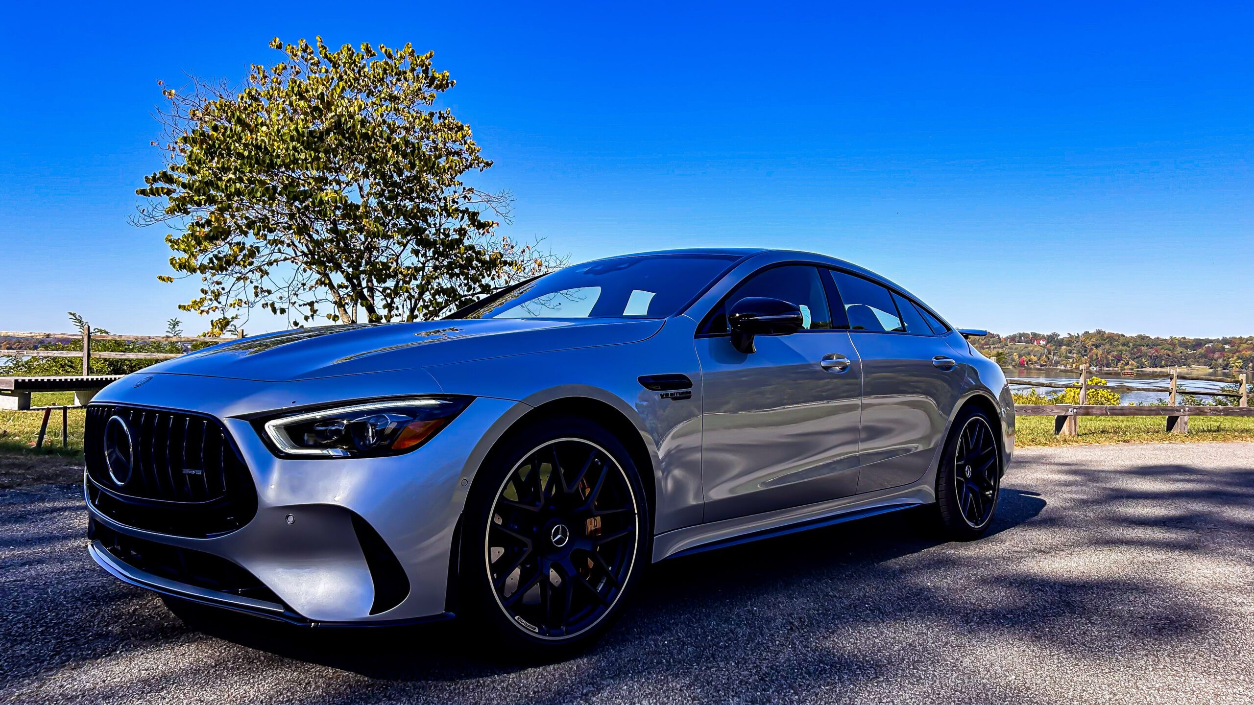 Sleek silver sports car parked under clear blue sky.