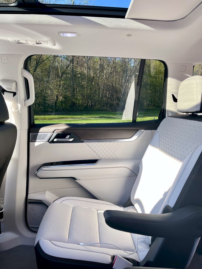 2025 GMC Acadia Denali driving on the road during a test drive showing road presence and handling