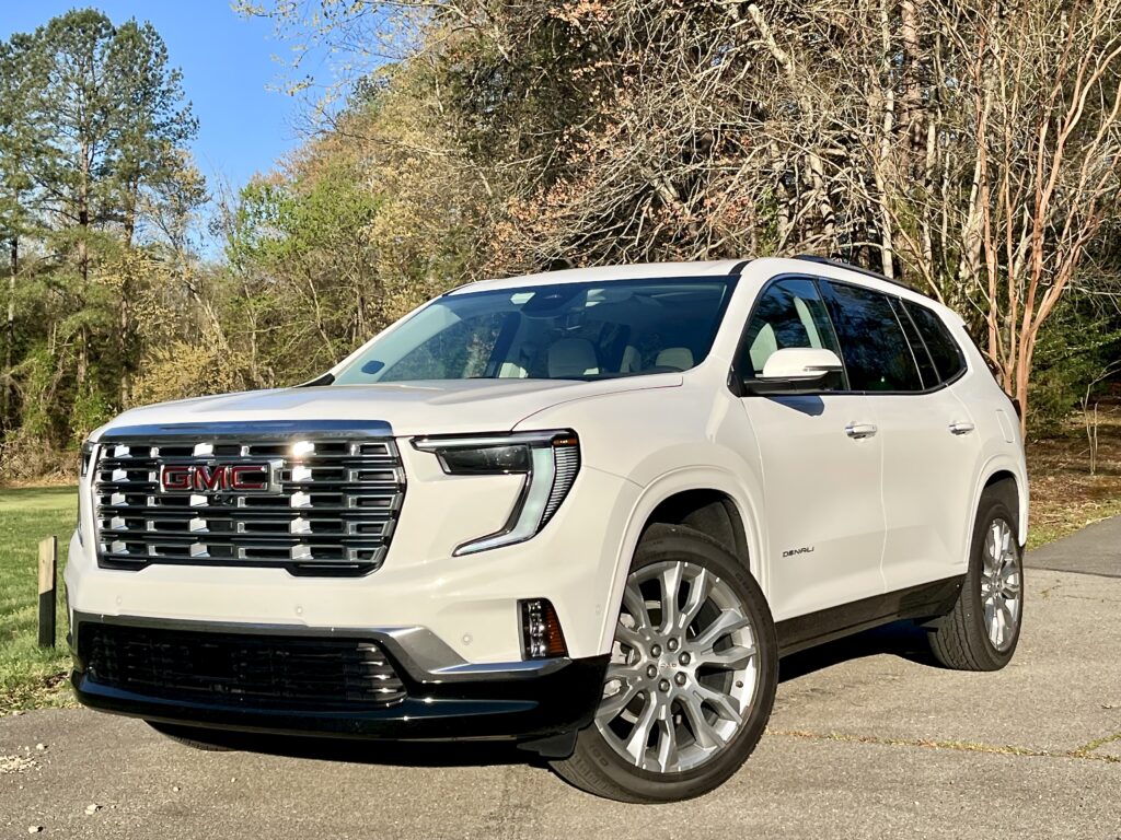 2025 GMC Acadia Denali driving on the road during a test drive showing road presence and handling