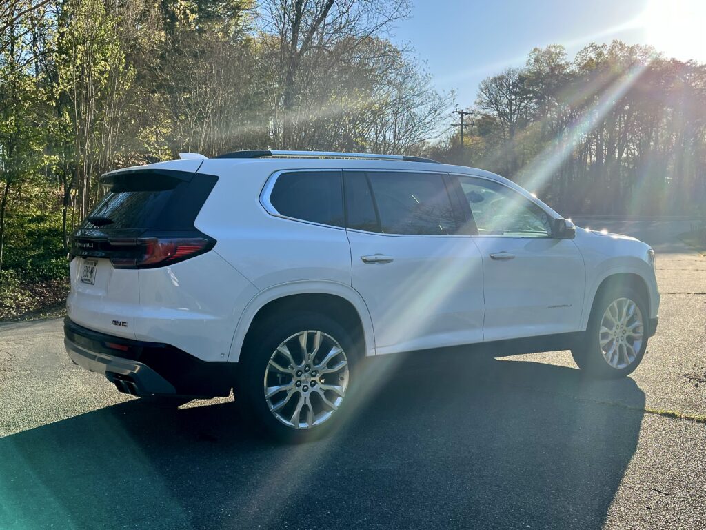 2025 GMC Acadia Denali driving on the road during a test drive showing road presence and handling