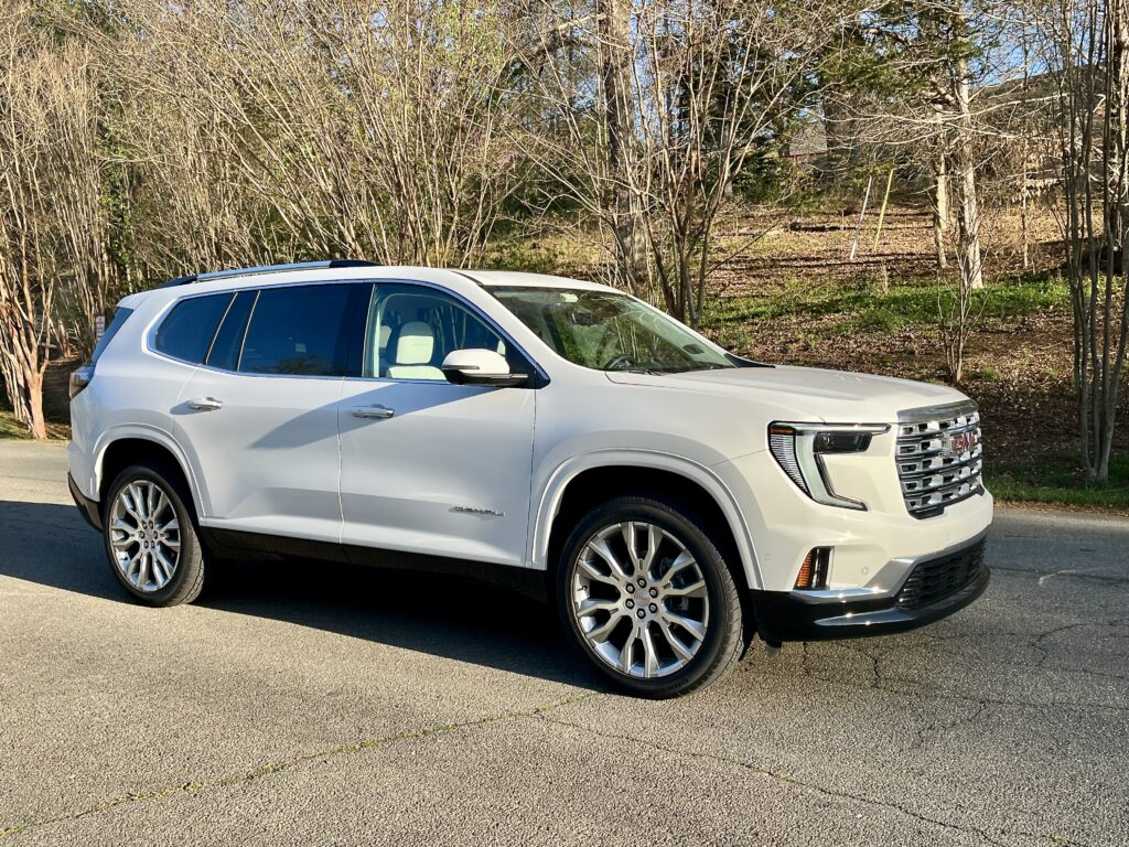 2025 GMC Acadia Denali driving on the road during a test drive showing road presence and handling