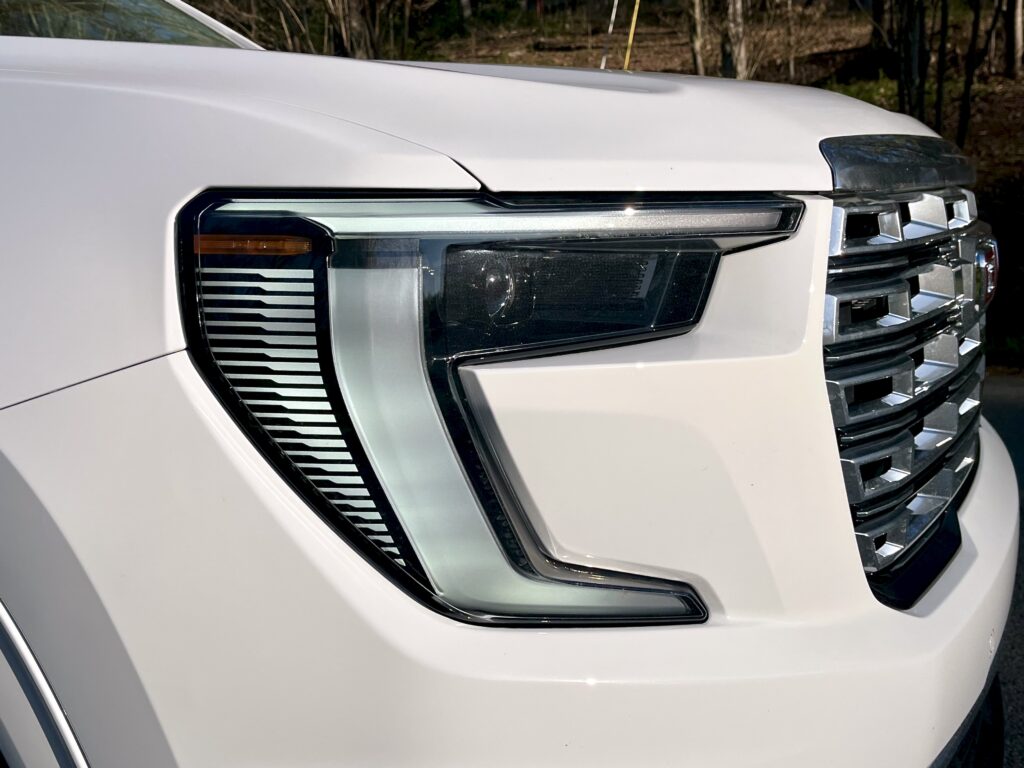 2025 GMC Acadia Denali driving on the road during a test drive showing road presence and handling