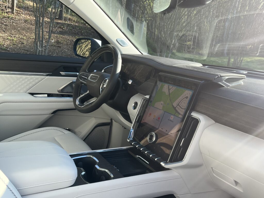2025 GMC Acadia Denali driving on the road during a test drive showing road presence and handling