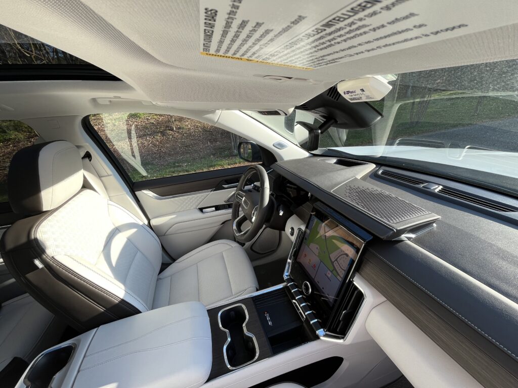 2025 GMC Acadia Denali driving on the road during a test drive showing road presence and handling