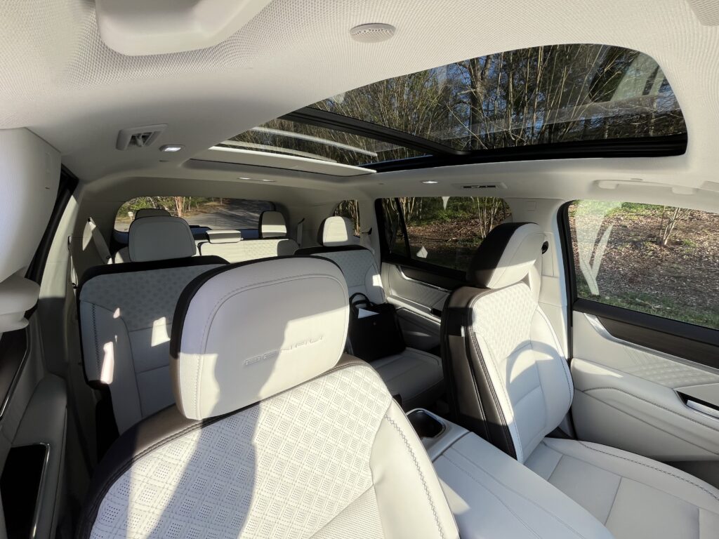 2025 GMC Acadia Denali driving on the road during a test drive showing road presence and handling